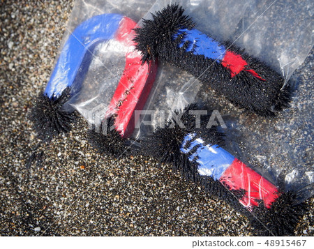 Sand iron removal using a magnet on a sandy beach 48915467