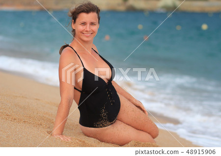 Pretty woman in swimwear on sandy beach Pretty woman in swimwear on sandy beach 48915906