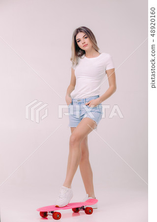 beautiful woman in white t-shirt with pink skateboard beautiful woman in white t-shirt with pink skateboard 48920160