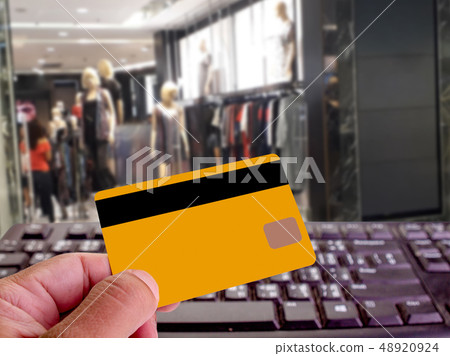 holding credit card and using the computer. 48920924