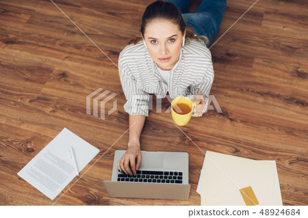 Young female working on floor with laptop 48924684