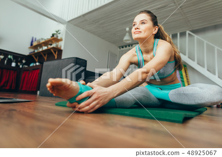 Attractive woman practicing head to knee yoga pose 48925067