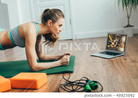 Young lady doing plank practice at home Young lady doing plank practice at home 48925092