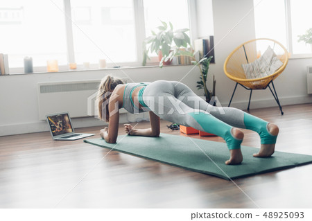 Young lady doing plank aerobics practice at home Young lady doing plank aerobics practice at home 48925093