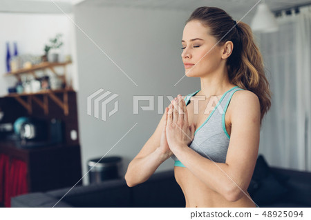 Young balanced lady holding hands in namaste Young balanced lady holding hands in namaste 48925094