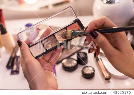 Cropped photo of female arms with rouge and brush 48925170