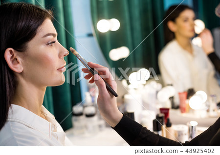 Side view of beautiful Caucasian woman in beauty studio sitting at mirror Side view of beautiful Caucasian woman in beauty studio sitting at mirror 48925402