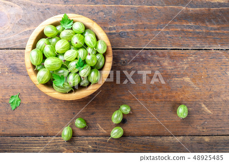 Ripe green gooseberries in a wooden bowl. Ripe green gooseberries in a wooden bowl. 48925485