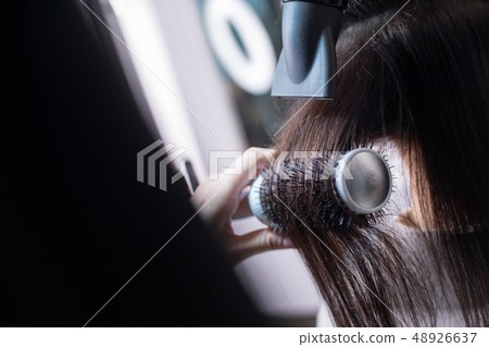 Hairdresser is making fashionable hairstyle for client in barber shop 48926637