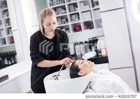 Waist up photo of barber and brunette lady in modern barbershop Waist up photo of barber and brunette lady in modern barbershop 48926707