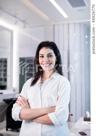 Low angle of happy brunette lady posing for camera in beauty saloon Low angle of happy brunette lady posing for camera in beauty saloon 48926770