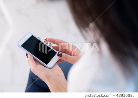 Cropped photo of woman holding her digital device in hands Cropped photo of woman holding her digital device in hands 48926883