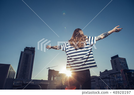 Rear view of along haired man enjoying sunbeams Rear view of along haired man enjoying sunbeams 48928197
