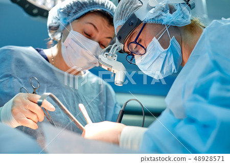 Portrait of professional surgeons during surgery on a blue background. Concept surgery, medicine 48928571