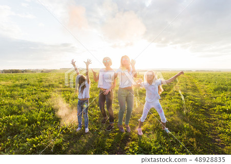 Indian holidays, fun and Holi festival concept - Jumping happy women and girls covered in paint 48928835
