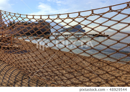 Fishing net dries in the sun and is blown Fishing net dries in the sun and is blown 48929544