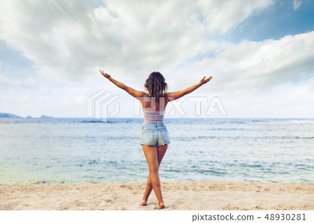 Freedom and happiness woman on beach. She is enjoying serene ocean nature during travel holidays Freedom and happiness woman on beach. She is enjoying serene ocean nature during travel holidays 48930281