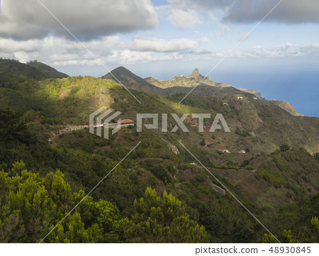 view on Monte Taborno with green hills, houses and blue sky white clouds in anaga mountain, tenerife view on Monte Taborno with green hills, houses and blue sky white clouds in anaga mountain, tenerife 48930845