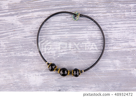 A necklace with black beads from agate on a rubber 48932472