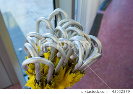 grey handles of yellow umbrellas set at the exit 48932879