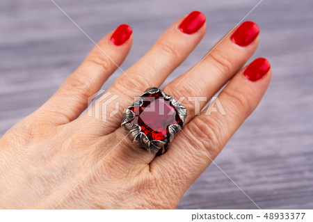 A ring with ruby quartz on a hand A ring with ruby quartz on a hand 48933377