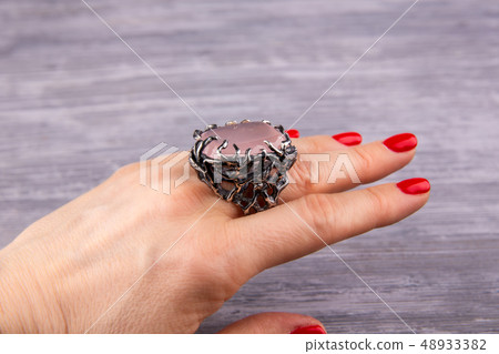 A ring with rose quartz on a hand A ring with rose quartz on a hand 48933382