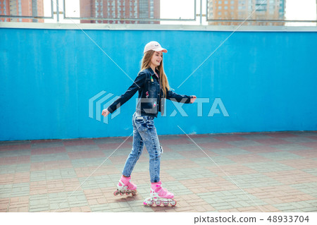 Teenager girl riding on roller skates at outdoor skate park 48933704