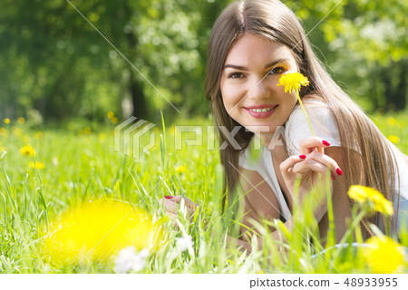 Woman laying on grass in park Woman laying on grass in park 48933955
