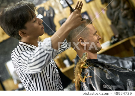 Man is cutting his hair in asian barbershop Man is cutting his hair in asian barbershop 48934729