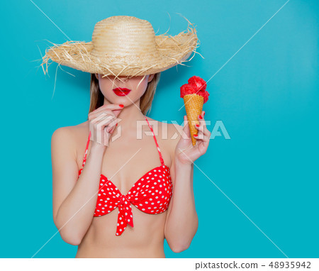 Young woman in red bikini and straw hat with ice cream Young woman in red bikini and straw hat with ice cream 48935942