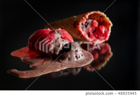 Melted chocolate and raspberry ice cream on glass 48935945
