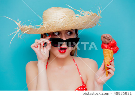 Young woman in red bikini and straw hat with ice cream Young woman in red bikini and straw hat with ice cream 48935951