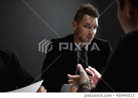 Detectives in interrogation room with suspect or Detectives in interrogation room with suspect or 48940013
