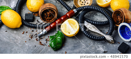 Smoking hookah with lemon flavor Smoking hookah with lemon flavor 48941570