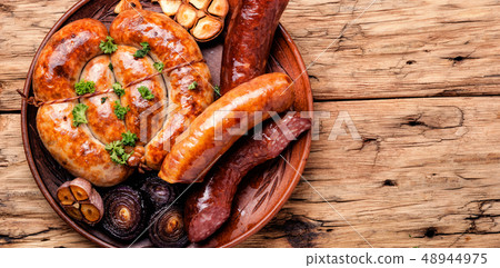 Grilled sausages on wooden board 48944975
