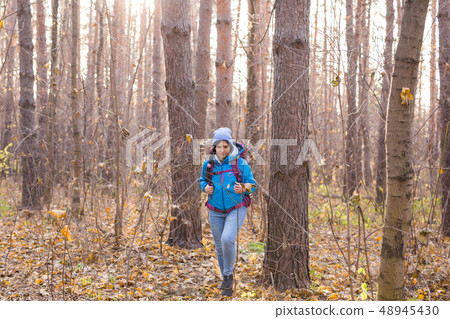 adventure, travel, tourism, hike and people concept - Attractive smiling tourist woman walking in 48945430