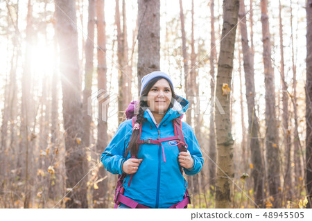 adventure, travel, tourism, hike and people concept - Attractive smiling tourist woman walking in 48945505