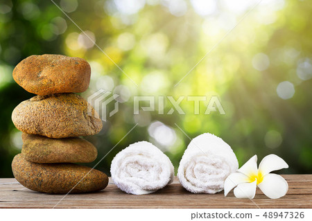 Stack of stone and white towel with flower on Stack of stone and white towel with flower on 48947326