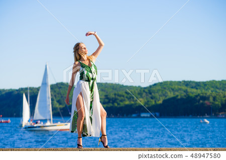 Woman in summer long dress against sea Woman in summer long dress against sea 48947580