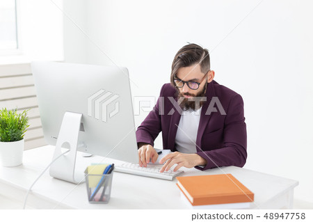 People and technology concept - Attractive man with beard working on at the computer 48947758