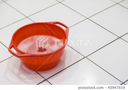 Red bowl filled with detergent and water 48947839