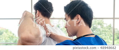Physical therapist stretching athlete male patient 48948682