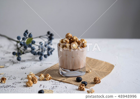 Cocoa with chocolate popcorn on a white table. Cocoa with chocolate popcorn on a white table. 48948996