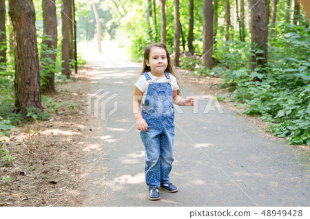 Children, childhood and nature concept - Portrait of beautiful small baby girl playing in the park 48949428