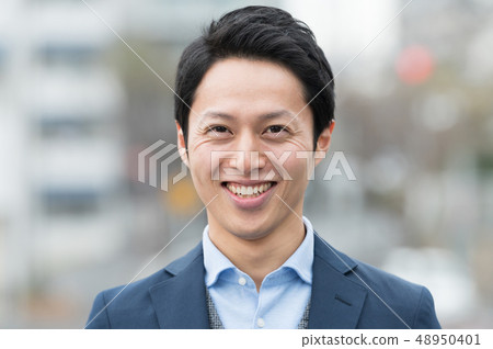 Young Japanese man standing outdoors Young Japanese man standing outdoors 48950401