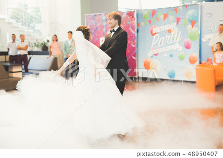 Beautiful caucasian wedding couple just married and dancing their first dance 48950407