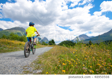 Child on a bicycle in a nature road Child on a bicycle in a nature road 48950508