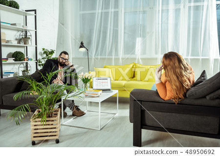 Serious bearded practitioner listening to his visitor Serious bearded practitioner listening to his visitor 48950692