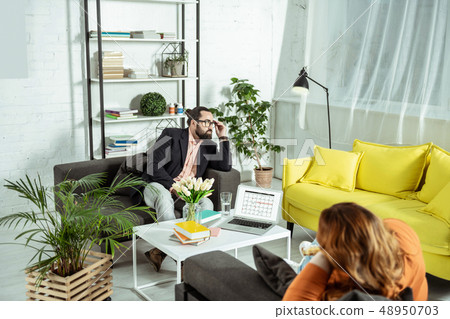 Serious bearded man looking aside at window Serious bearded man looking aside at window 48950703