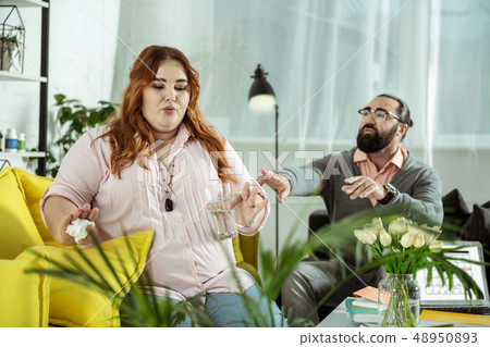 Attentive overweight female person working with psychologist 48950893